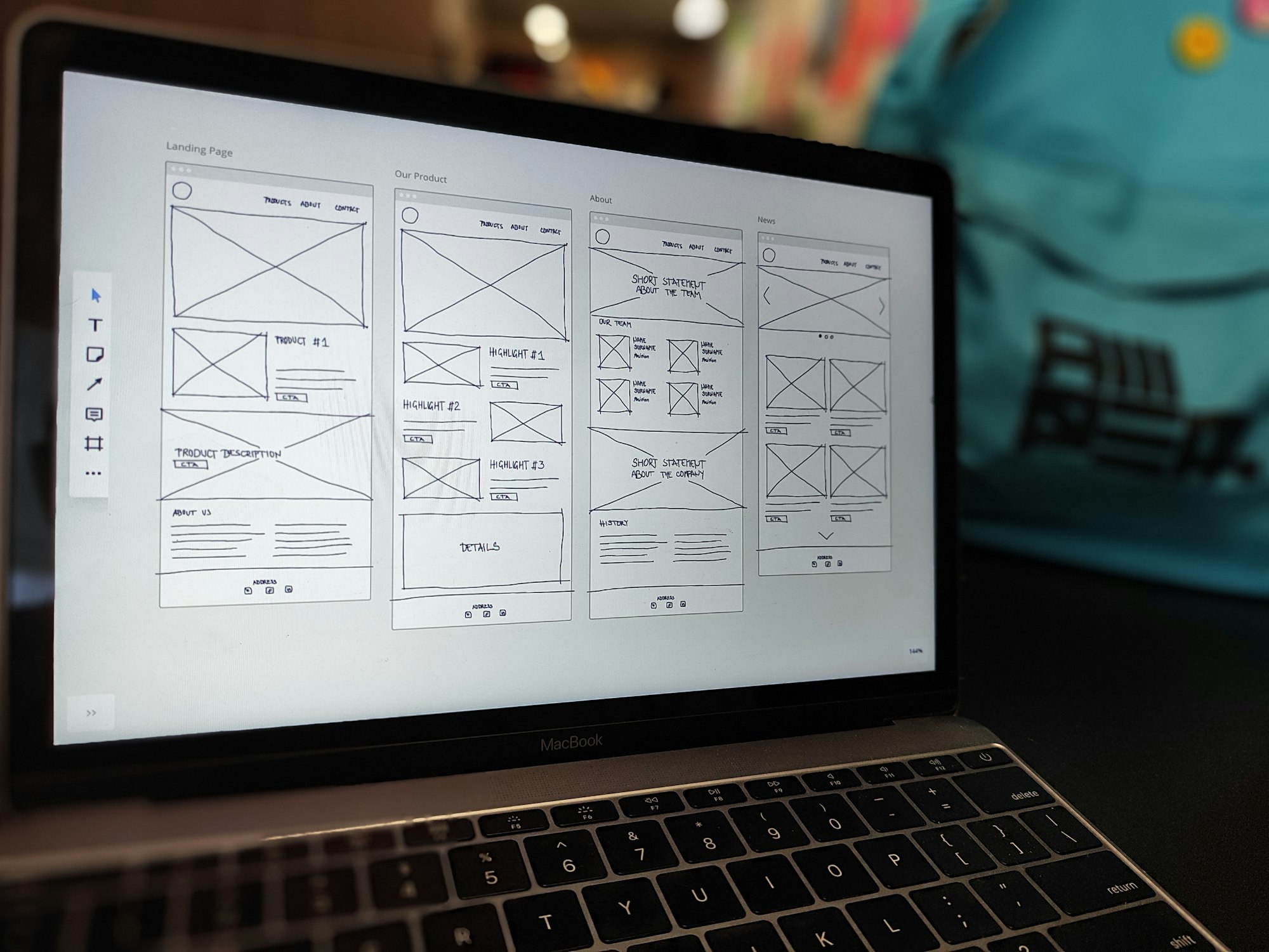 Bir MacBook ekranında elle çizilmiş website wireframe taslakları